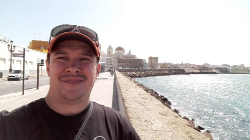 Portrait of young man standing on retaining wall