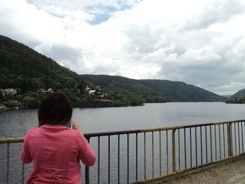 Man sitting on bench by lake