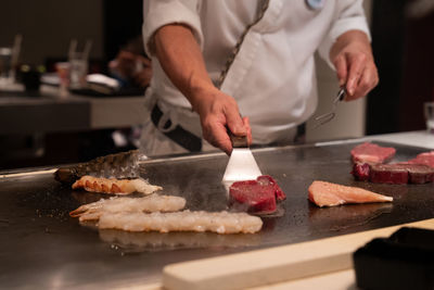 Midsection of chef preparing food on table