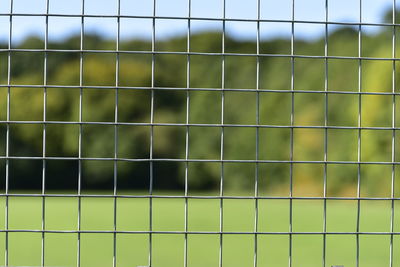 Full frame shot of metallic fence on field