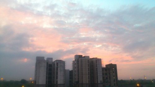 Skyscrapers in city at sunset