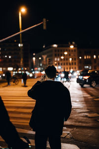 Rear view of a man and woman walking in city