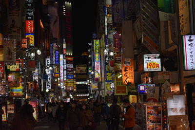 People on illuminated street at night