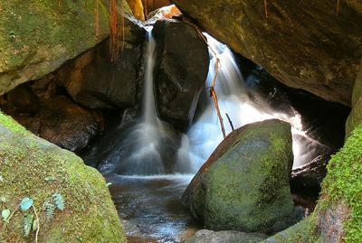 Water falling through moss covered rocks