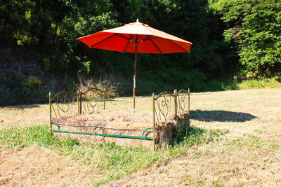 Umbrella on field against trees