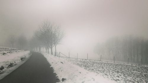 Snow covered road passing through landscape