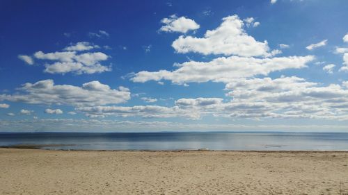 Scenic view of beach against cloudy sky