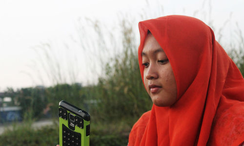 Close-up of woman in headscarf taking selfie outdoors