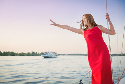 Beautiful woman posing on the yacht at a sunny summer day at the river