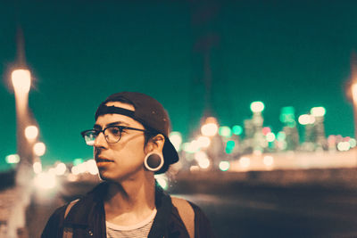 Young man looking at city at night