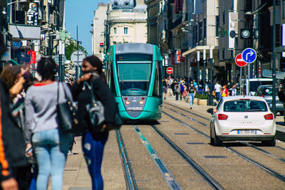 Rear view of people walking on city street