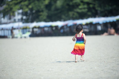 Rear view of woman walking on beach