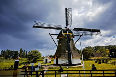 Traditional windmill on field against sky