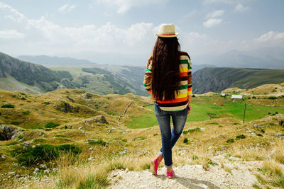 Woman on mountain against sky