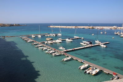 Boats moored on sea against clear sky