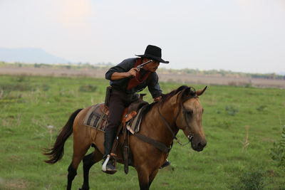 Horse riding horses in a field