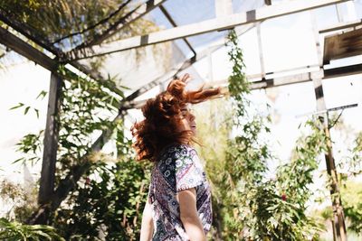 Low angle view of woman standing by plants