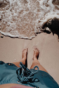 Low section of person on sand at beach