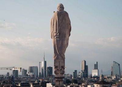 Statue of city buildings against sky