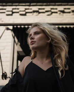 Portrait of young woman looking away outdoors