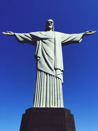 Low angle view of statue against blue sky