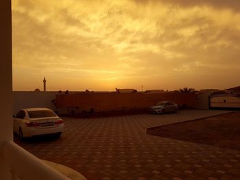 Cars on road against sky during sunset