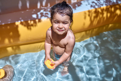 A little girl playing with rubber ducks in the pool. concept of fun