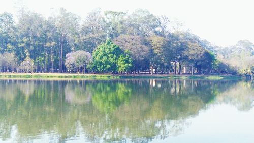 Scenic view of lake by trees against sky