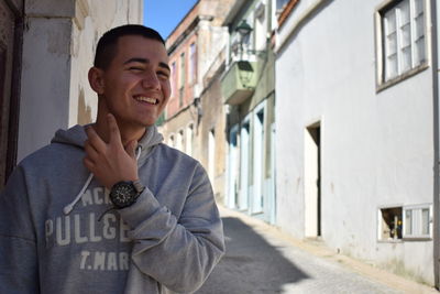 Portrait of young man standing against building