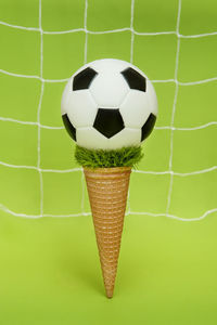 Close-up of ball on table against green background