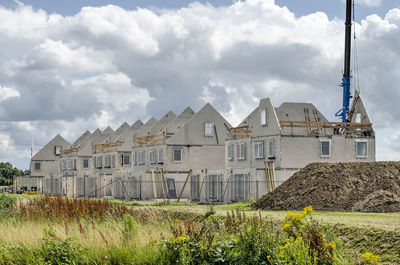 Houses on field against sky