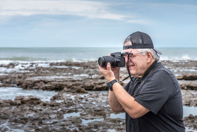 Young man photographing with camera