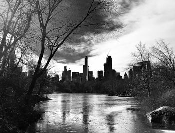 Scenic view of river by buildings against sky