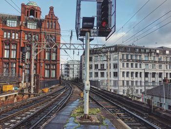 Railroad tracks in city against sky