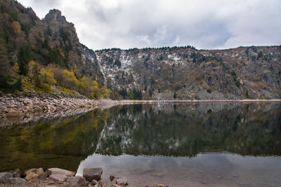 Scenic view of lake by mountains against sky