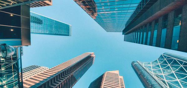 Low angle view of modern buildings against clear blue sky