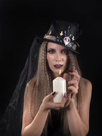 Midsection of woman using mobile phone against black background