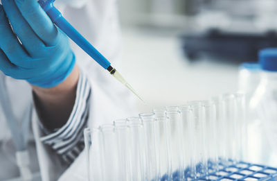 Midsection of scientist examining chemical in laboratory