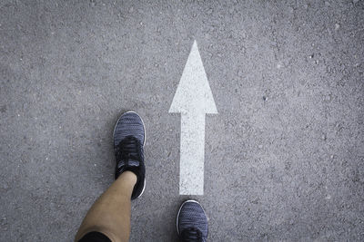 Low section of person standing on road