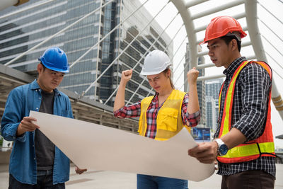 Engineers discussing over blueprint at construction site