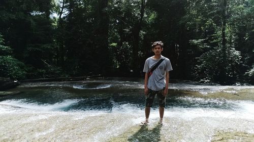 Portrait of smiling man standing in forest