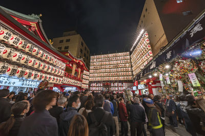 People at illuminated market in city at night