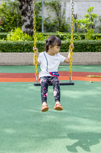 Full length of girl on swing at playground