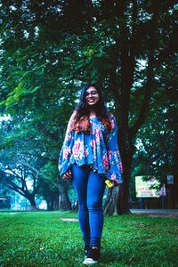 Portrait of young woman standing in park