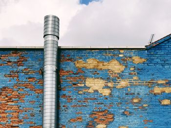 Metal pipe against brick wall