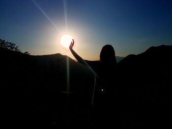 Silhouette man against sun during sunset