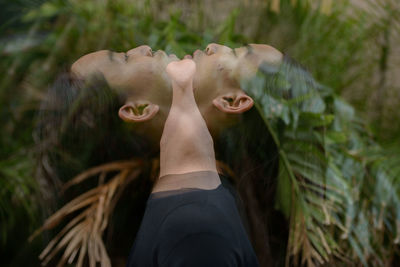 Multiple image of man by plants