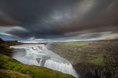 Scenic view of waterfall against sky