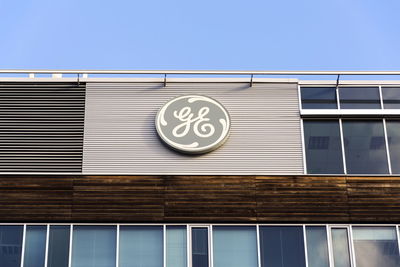 Low angle view of sign on building against sky