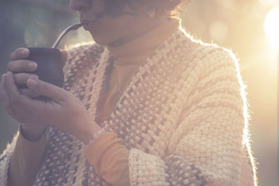 Midsection of man holding mobile phone in winter